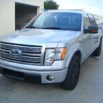 Before and after photographs of a damaged Ford pickup truck that was repaired by Elite Paint & Body Shop in West Palm Beach, Florida.